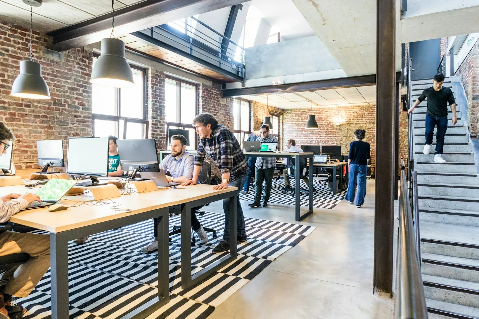 Colleagues working together at computers in an open-plan office